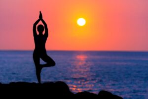 kvinde laver yoga i solnedgang